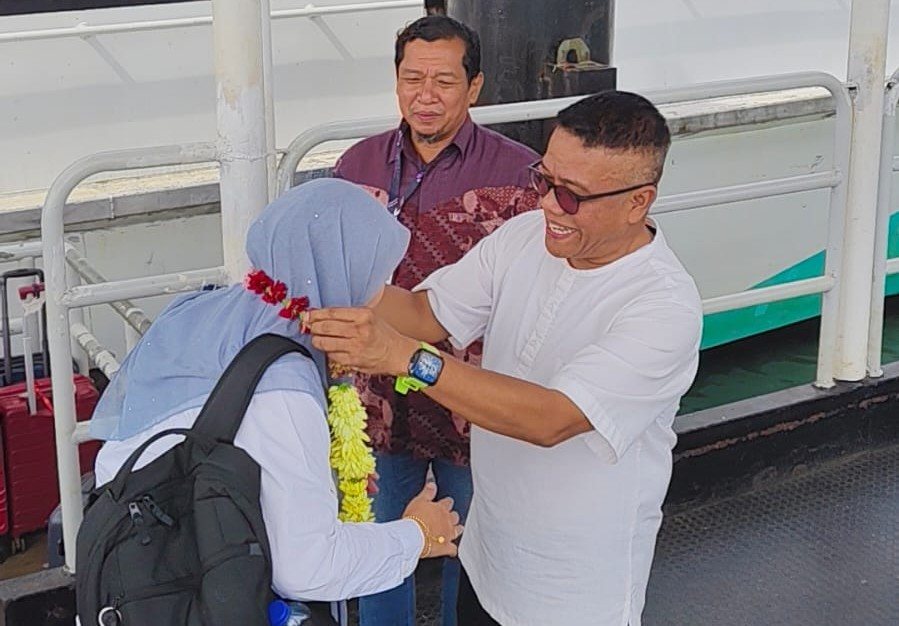 Kepala Dinas Kebudayaan dan Pariwisata Kota Batam menyerahkan bunga kepada Pengurus Besar Kanan PTPTN Malaysia, Wan Zawiyah Binti Wan Abubakar.